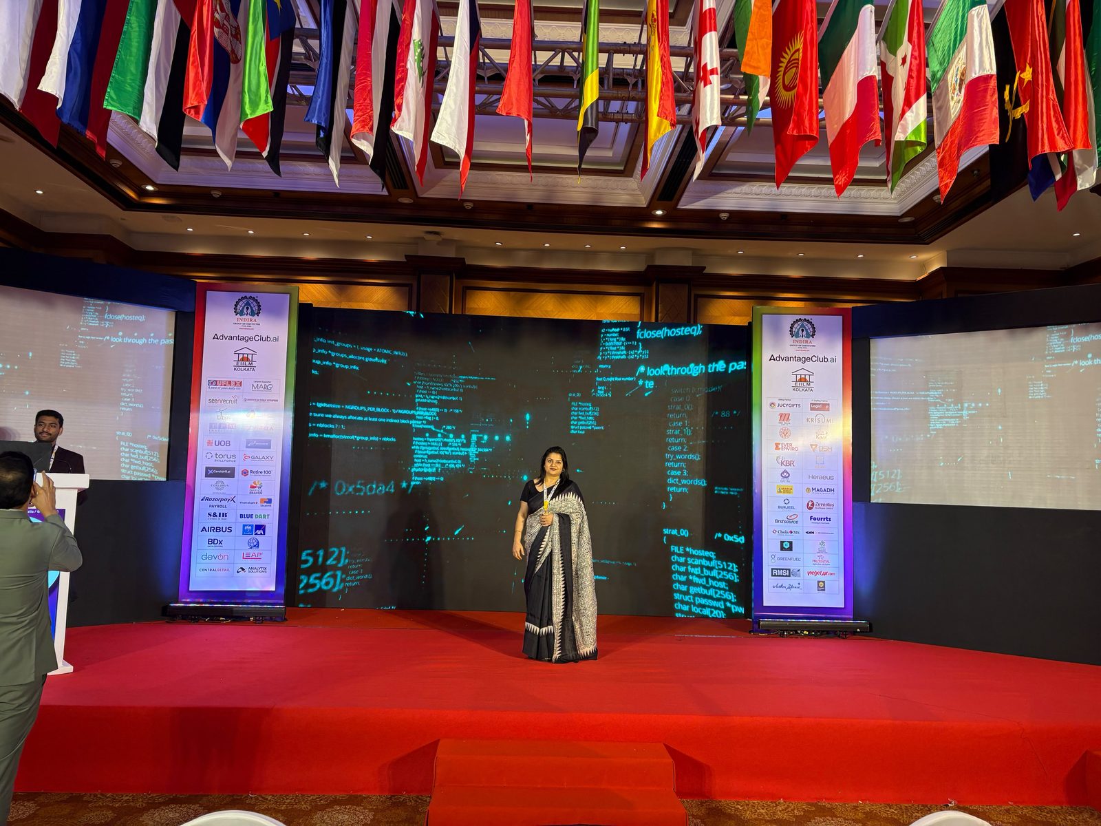 Shipra speaking beneath international flags